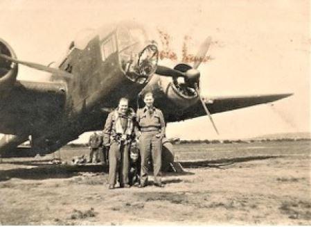 Jack Wreakes (crouched down) in front of a Vickers Wellington III with other Crewmen